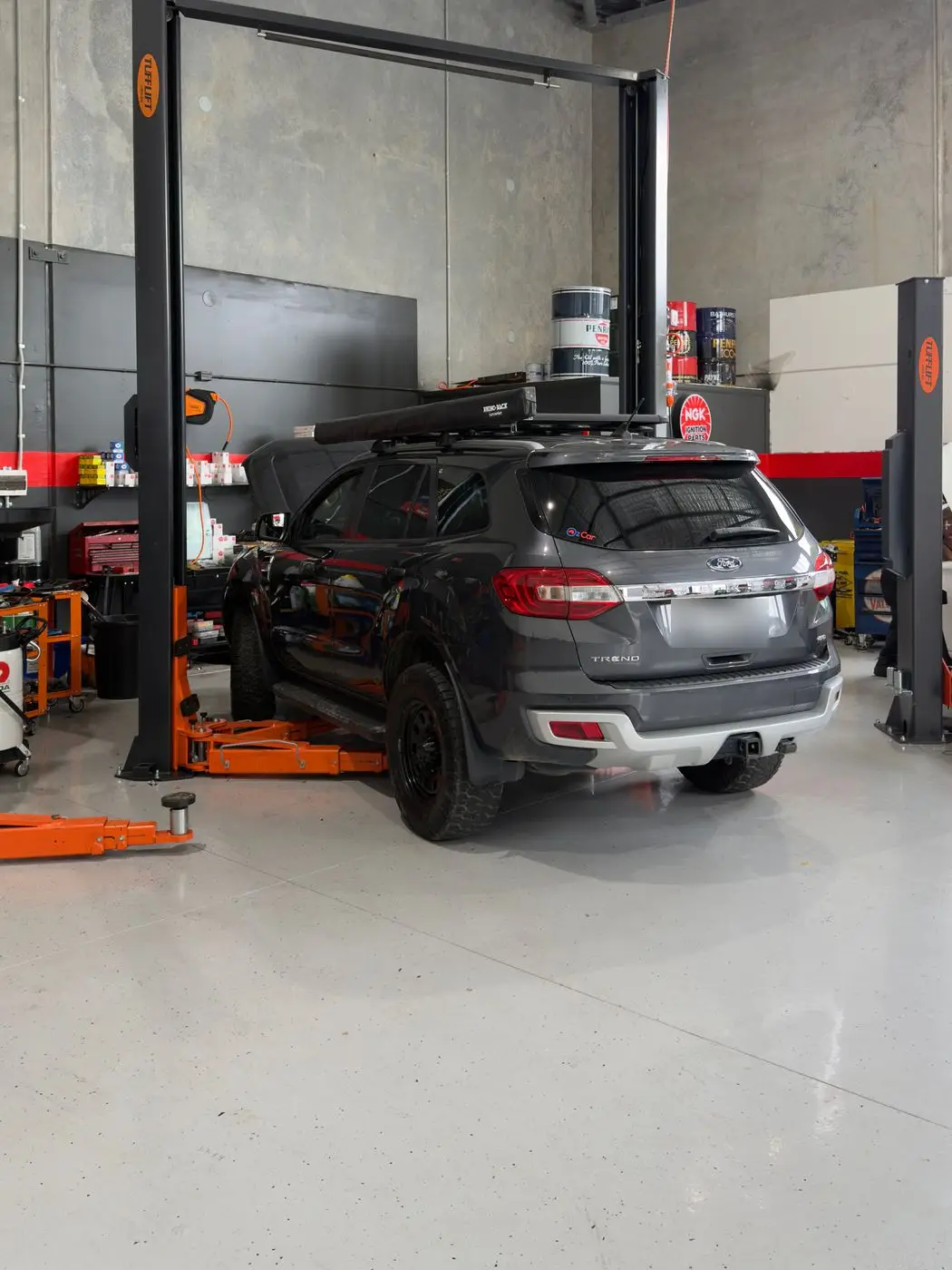SUV raised on a hoist for inspection in the SAI Motor Works workshop